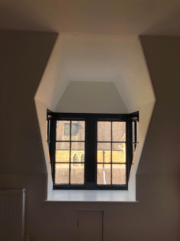 Box-shaped window in slanted roof of 19th century Abbey (UK) – does this type of window have a name?

A: It’s a dormer window. There are many different styles, but basically an extra bit of roof to allow a window above the roof line.