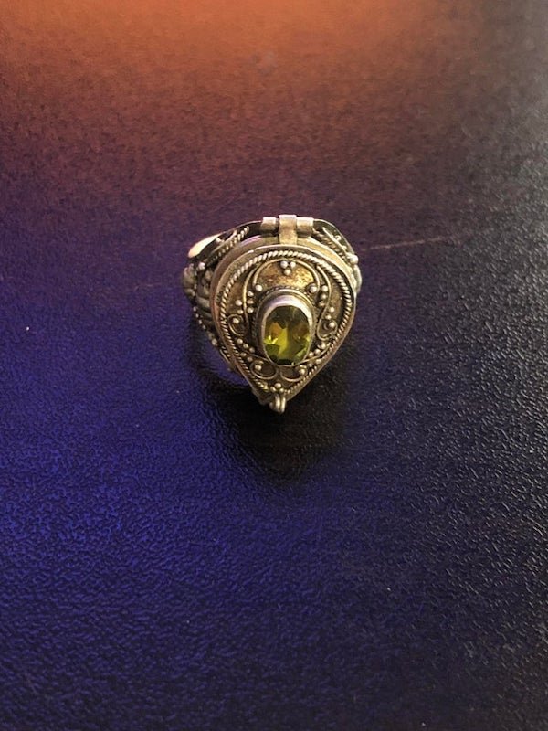 What is the purpose of a ring like this? It’s a sterling silver ring with a gemstone on top. The face of it is clasped shut and can be opened up to reveal little space for holding something.

A: This is a perfume ring which holds solid perfume. Ladies wore them way back in the day when there was more rotten stuff decomposing around towns, gutters & in the street. They would hold the ring to their nose when passing a stinky area. Some folks call them poison rings & there are locket rings, but Im pretty sure this is a perfume ring.