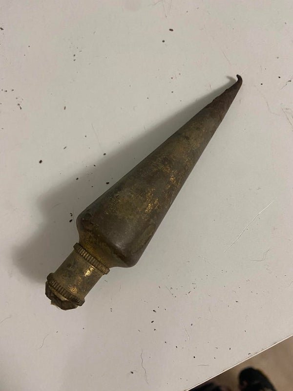 Found buried (not too deep) in my backyard. It’s very heavy, the nonpointed side looks like there was a wire there at some point

A: Plumb bob. It’s a weight with a pointed tip at the bottom to ensure that construction is vertical.