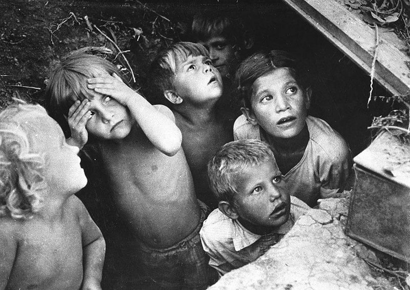 Soviet children watch as their neighborhood is bombed during a German air raid in Minsk, Belorussia. The bombing was part of Operation Barbarossa. June, 1941.