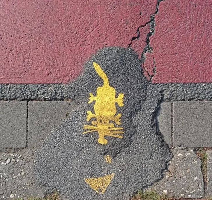 An anonymous person put tar patches between the road and the sidewalk so that cyclists have a smoother passage when crossing a street.