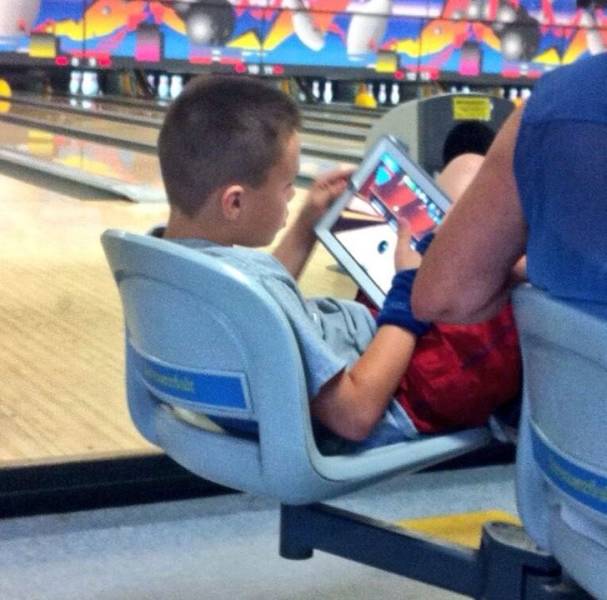 “This kid is playing a bowling game at a bowling alley.”