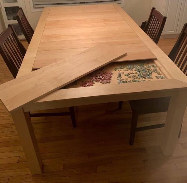 This dining table has a hidden game compartment under the table.