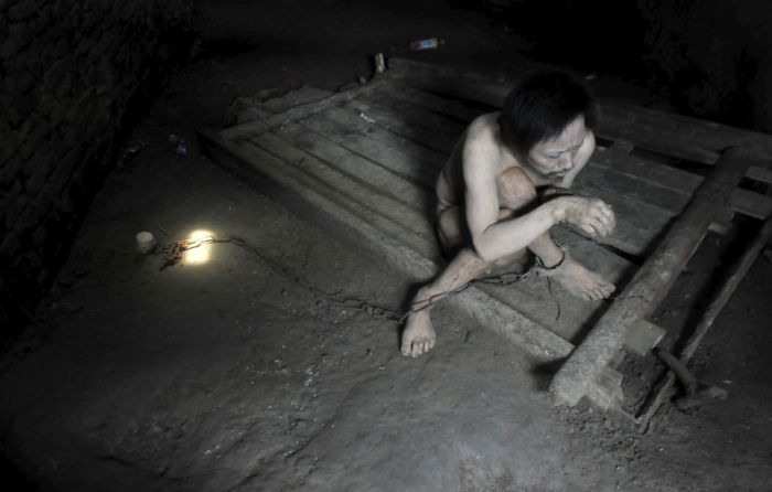 Tong Jieping, a 44-year-old mentally disabled man is chained by the foot inside his room. His parents, both in their 70s, could not afford the medical treatments, so they had to lock him up in chains to prevent him from running away.