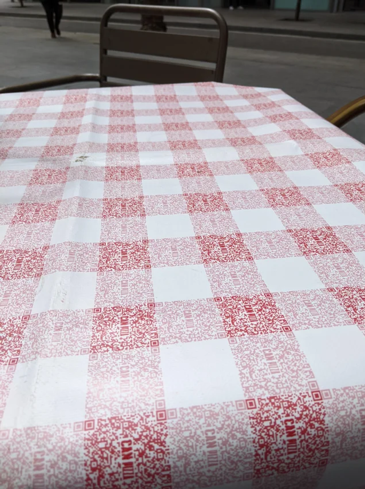 “The classic red checkered pattern of the tablecloth from this restaurant is made of QR codes for their menu.”