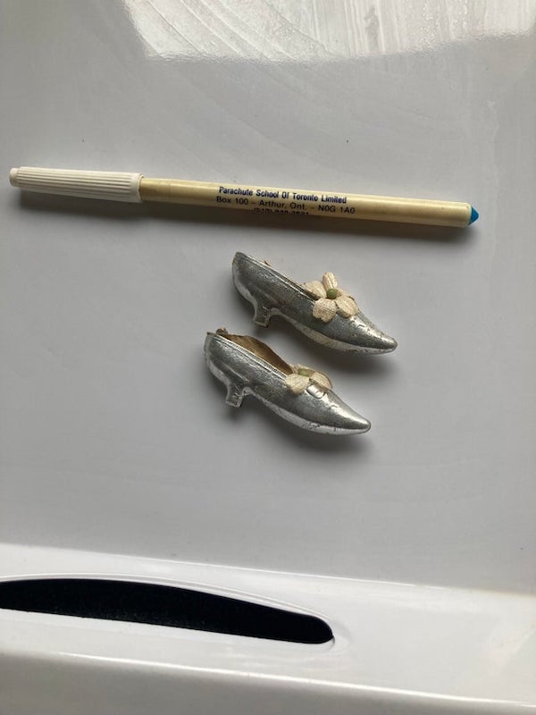 Small thin silver shoes found in recently deceased’s closest personal belongings (Pen for scale)

My mum had these. Commonly they were wedding cake decorations along with horseshoes and the like and were then given to guests as favours. I think around the 70s.