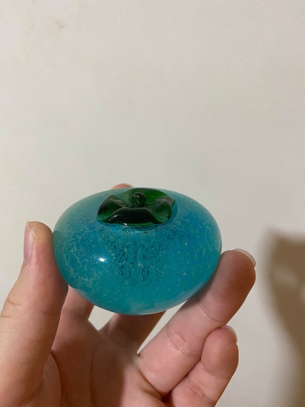 Bought this 10 years ago in Taiwan. It looks and feels like glass but I’ve dropped it many times without it shattering. It glows in the dark as well. What is it?

It’s blown glass
