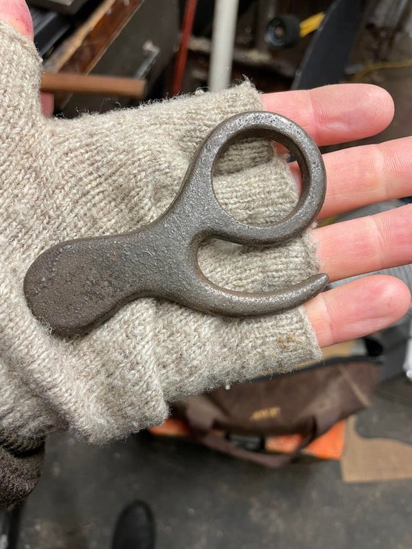 Found in family members workshop, appears to be cast steel or iron, hand for scale.

A: It’s a vintage mailbag hook.