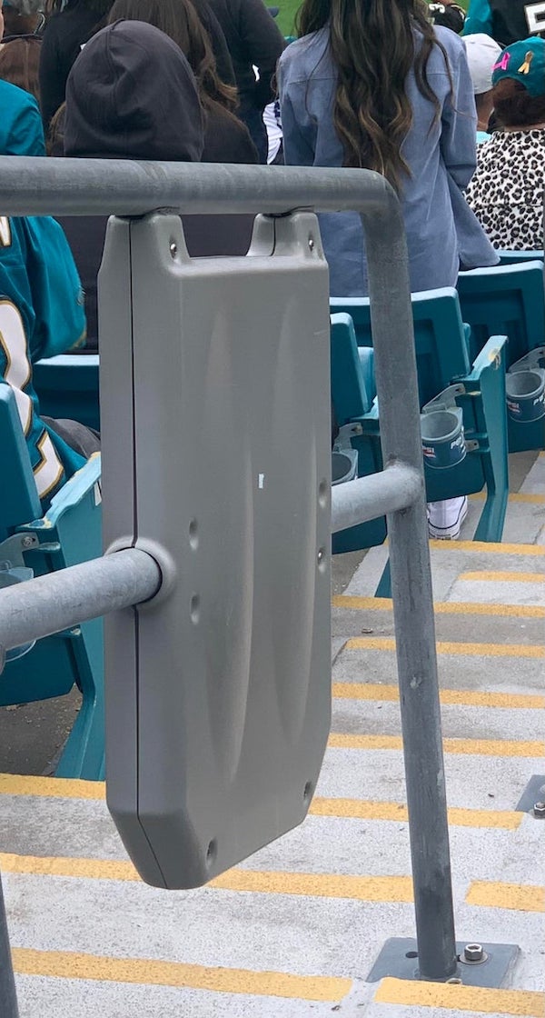 Plastic box attached to some of the railings in an NFL stadium.

A: At Mercedes Benz stadium in Atlanta, many of them have the Xfinity logo on them, so I believe they house wifi antennas!