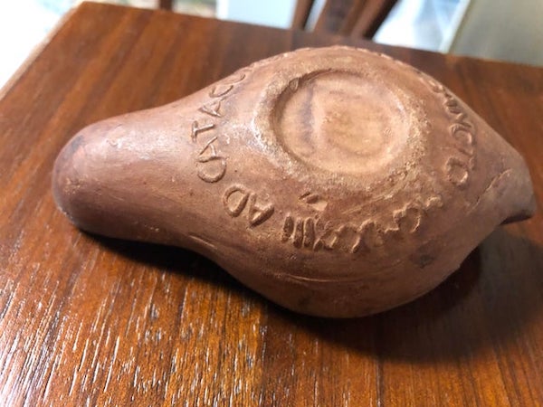 I found this religious clay thing. It’s probably from Appalachia, but possibly Europe. The back says “AD CATACUMBAS ANNO SANCTUM MCMXXXIII”

A: It’s an oil lamp