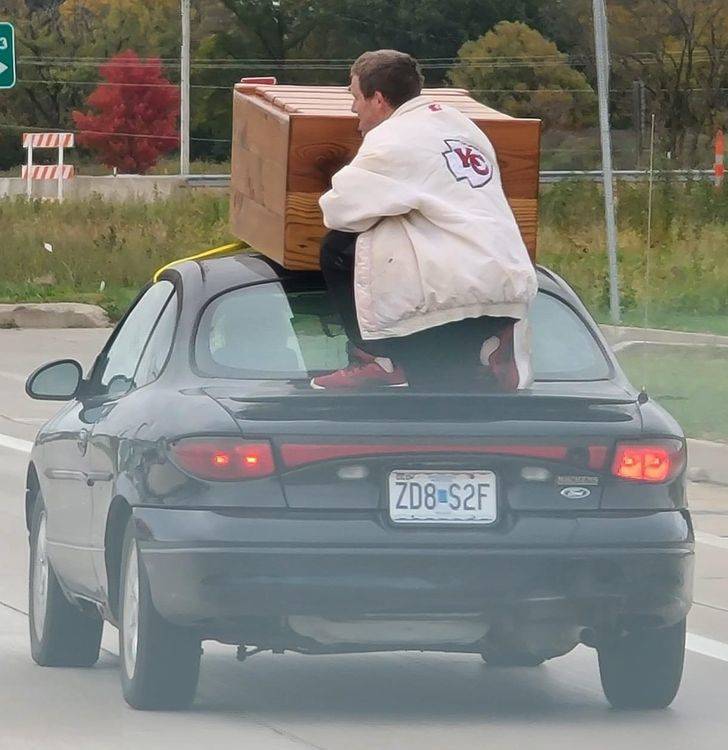 “A guy riding down the road holding a dresser on top of a car on a 50 MPH road”