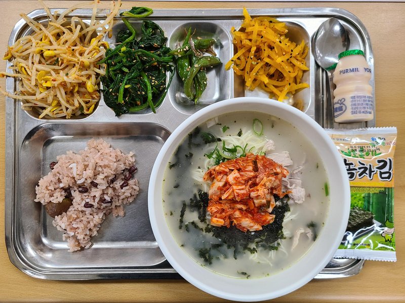 Korean School Lunch of Beef Noodle Soup with Kimchi, Sticky rice, and Various Banchan
