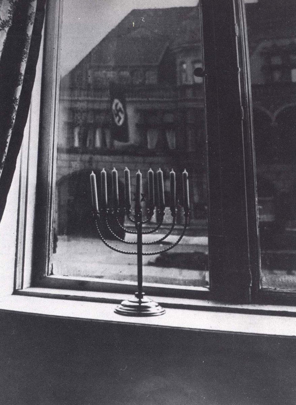 A menorah stands on the windowsill of a Jewish home across from Nazi Party headquarters in Kiel, Germany in 1932