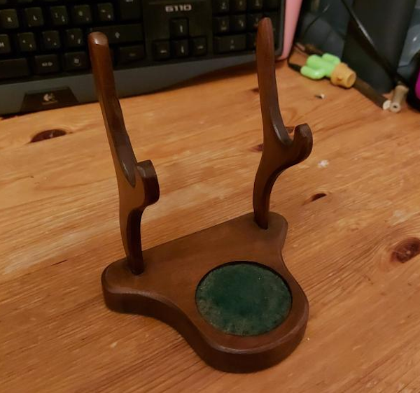 What is the purpose of the soft green circular part in the base of this small display stand?

A: This is a cup and saucer stand.