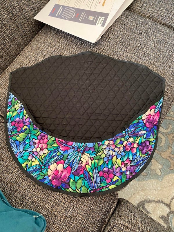 Xmas gift from MIL. The bottom has a pouch on the black side. No clasps/handles/straps. Made of similar fabric to a potholder or oven mitt, but it’s huge. Approx 1.5-2 ft across.

A: It’s a steering wheel cover to prevent the sun heating it up in summer.
