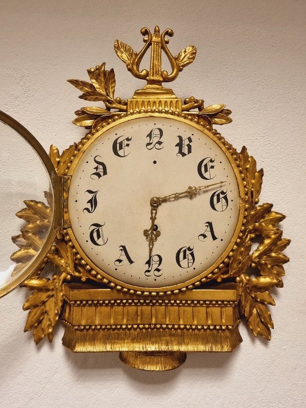 What is the meaning of these characters on the vintage clock face?

A: It says “use the time” in Swedish. I’m sure the hands point to times where numbers would be otherwise, but the letters are just there as a decorative saying. Kind of like people having signs in their house that say things like “laugh often, love much” etc.