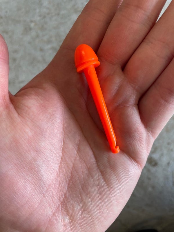 1 1/2 inches with hook on one end and cone with lip on other.

A: This thing fits inside of a small, yellow plastic cylinder, and there is a concealed rubber band inside. It’s a “magic“ trick, and it is designed to infuriate and frustrate your mark.