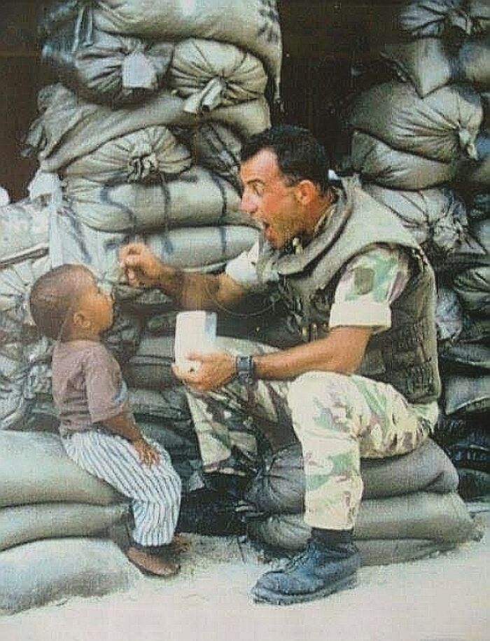 fascinating photos from history - Mogadishu, 1993. An Italian Soldier Gives Food To A Local Orphan