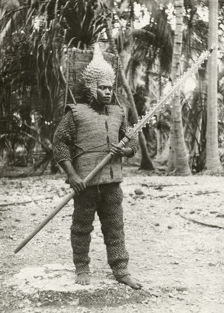The I-Kiribati “warrior” dressed for ceremony and battle in coir (coconut fiber) armor, pufferfish helmet, and armed with a shark tooth weapon.