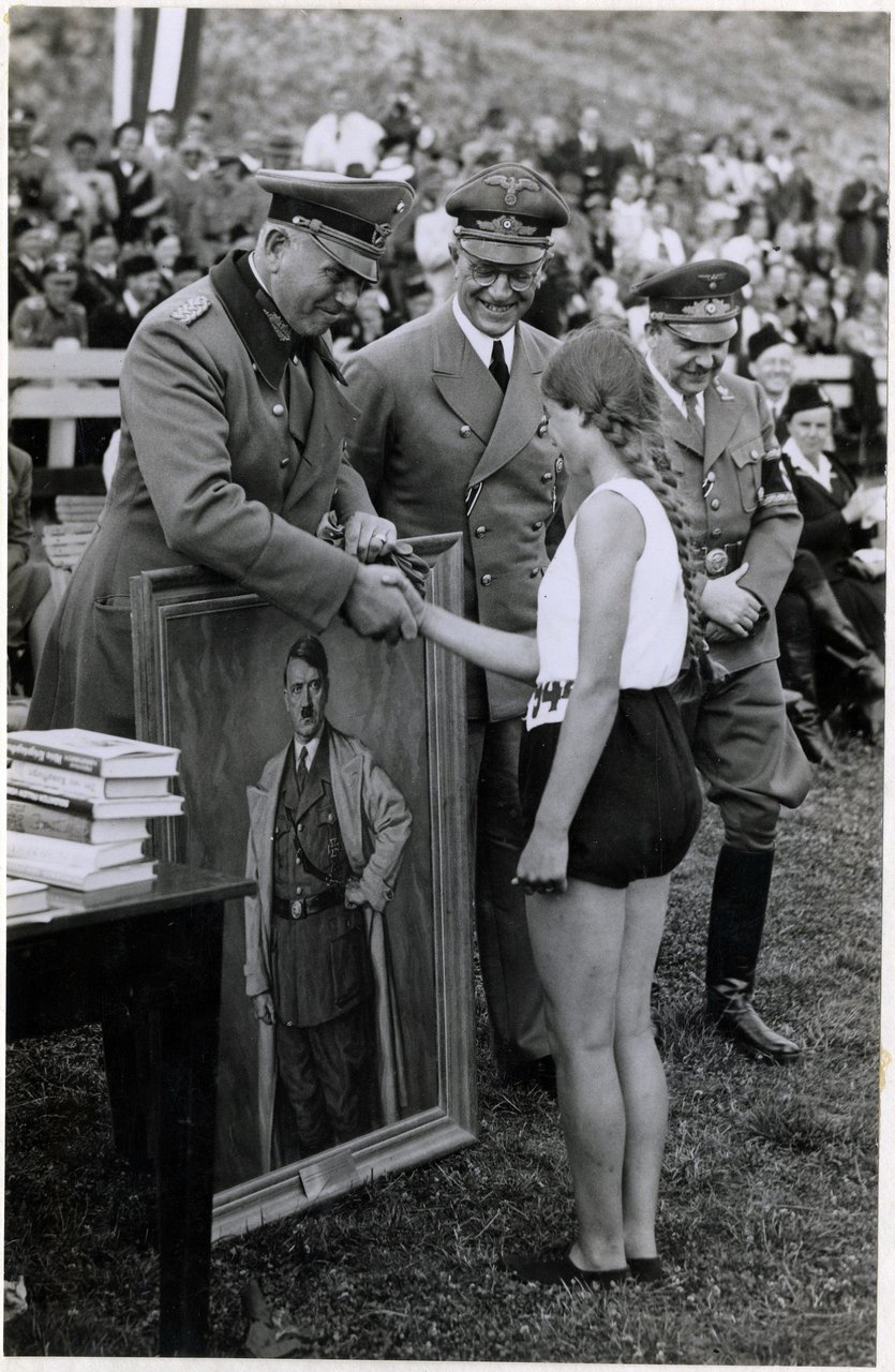 A Dutch athlete receives a portrait of Adolf Hitler as a sports prize, presented by General Otto Schumann, commander of the Ordnungspolizei. The Hague, The Netherlands, 1941