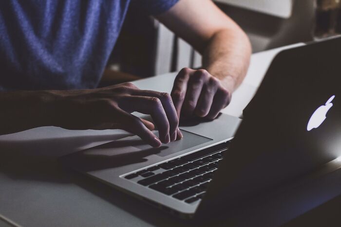 bad business decisions - person touching open macbook on table