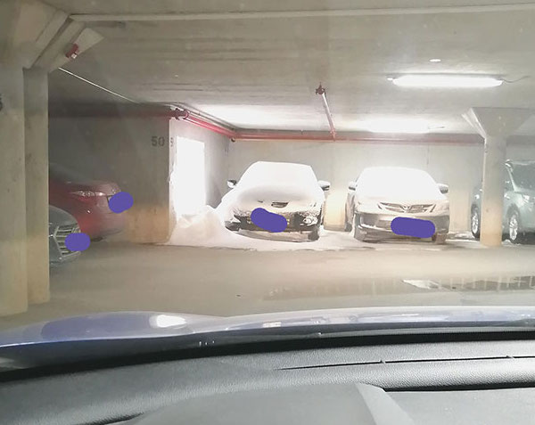 It snowed two feet overnight and this unlucky neighbour’s car in the underground parking lot is next to a large grate.