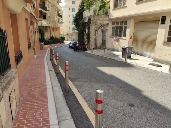 A street in two different countries – red sidewalk is Monaco, grey or no sidewalk is France