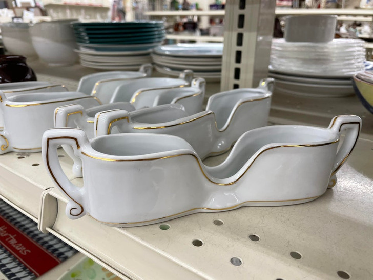 “White porcelain with decorative gold paint lines. The middle dips down and there are handles on both ends.” Answer: “It’s a silverware holder.”