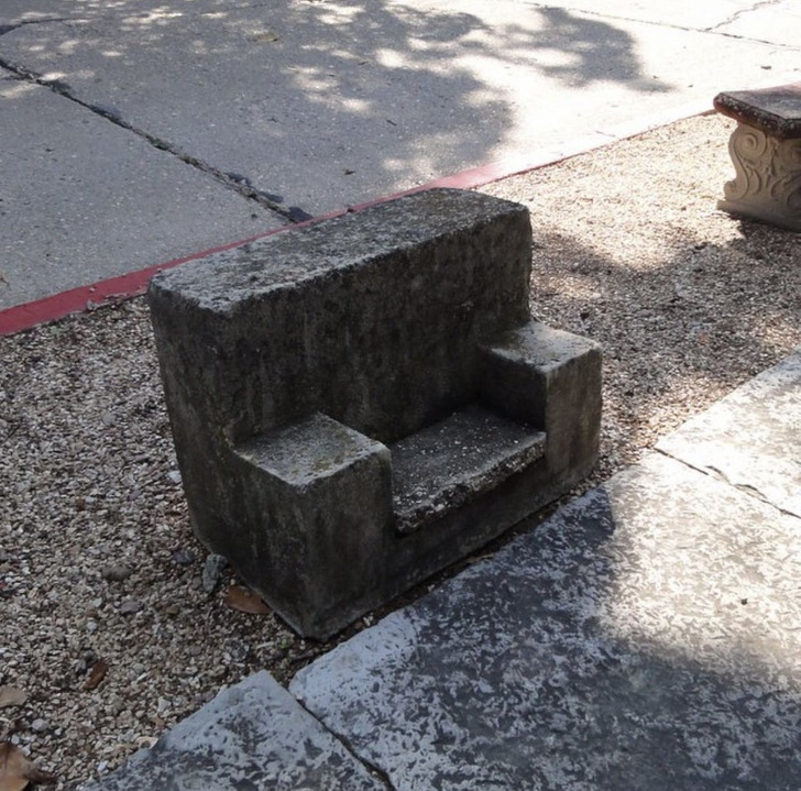 “It looks to be a very small concrete bench or seat facing away from the road near the curb. Too small for a child.” Answer: “They could be old carriage steps, used to help people get into and out of horse-drawn carriages.”