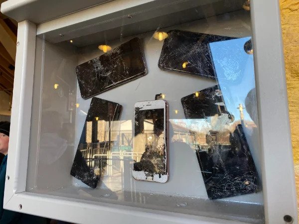 “These damaged phones on display next to a rollercoaster.”