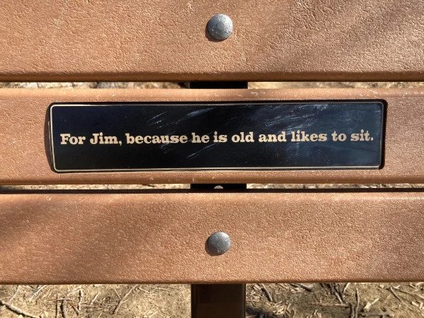 “A dedicated bench for Jim, some miles into a hiking trail.”