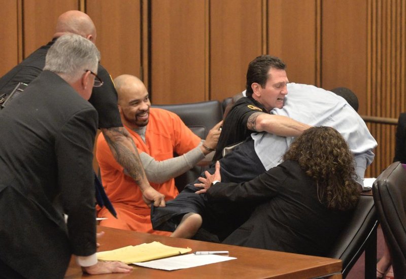 Michael Madison raped and murdered three women and stuffed their bodies into garbage bags. One of them was the 18-year-old daughter of Van Terry. When Michael smirked at Van Terry during his sentencing hearing, the older man lost his cool. This is Michael smiling as the police restrain Van Terry.