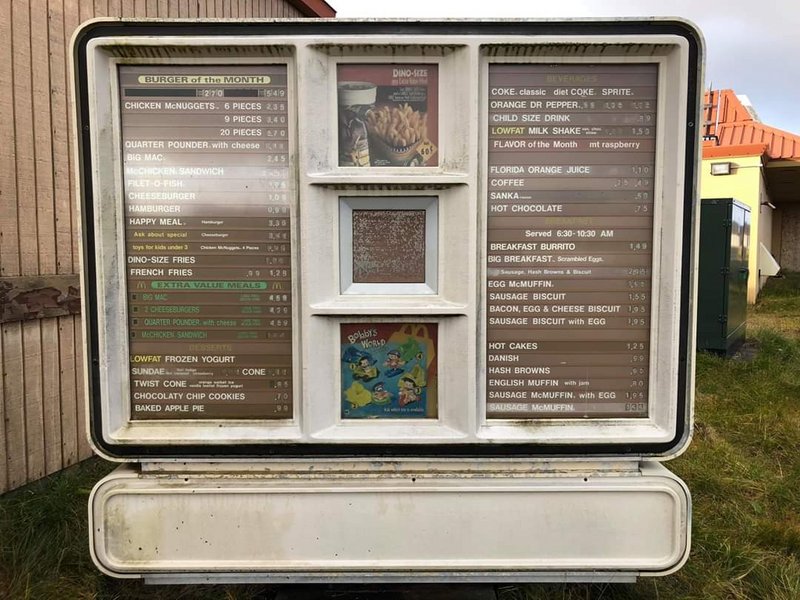 This is a drive-thru menu at a McDonalds in Adak, Alaska that was shuttered after the US Air Force closed it’s base. It’s got ‘Jurassic Park Dino-fries’ and ‘Bobby’s World merchandise’.