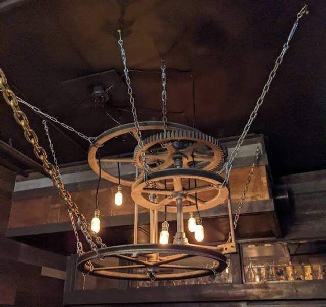 “Light ’fixture’ I noticed at a restaurant. Appears to be some sort of old machinery.”

Answer: "It’s the lift mechanism from a dumb waiter."