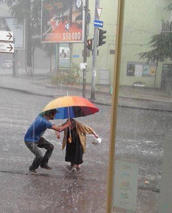 wholesome pics - man helping old woman in rain