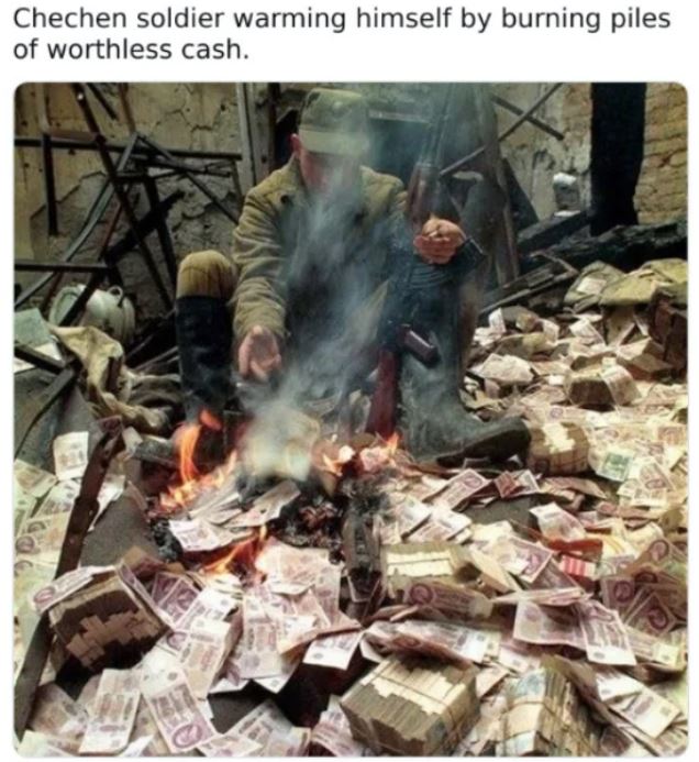 WTF History - chechen soldiers burn money - Chechen soldier warming himself by burning piles of worthless cash.