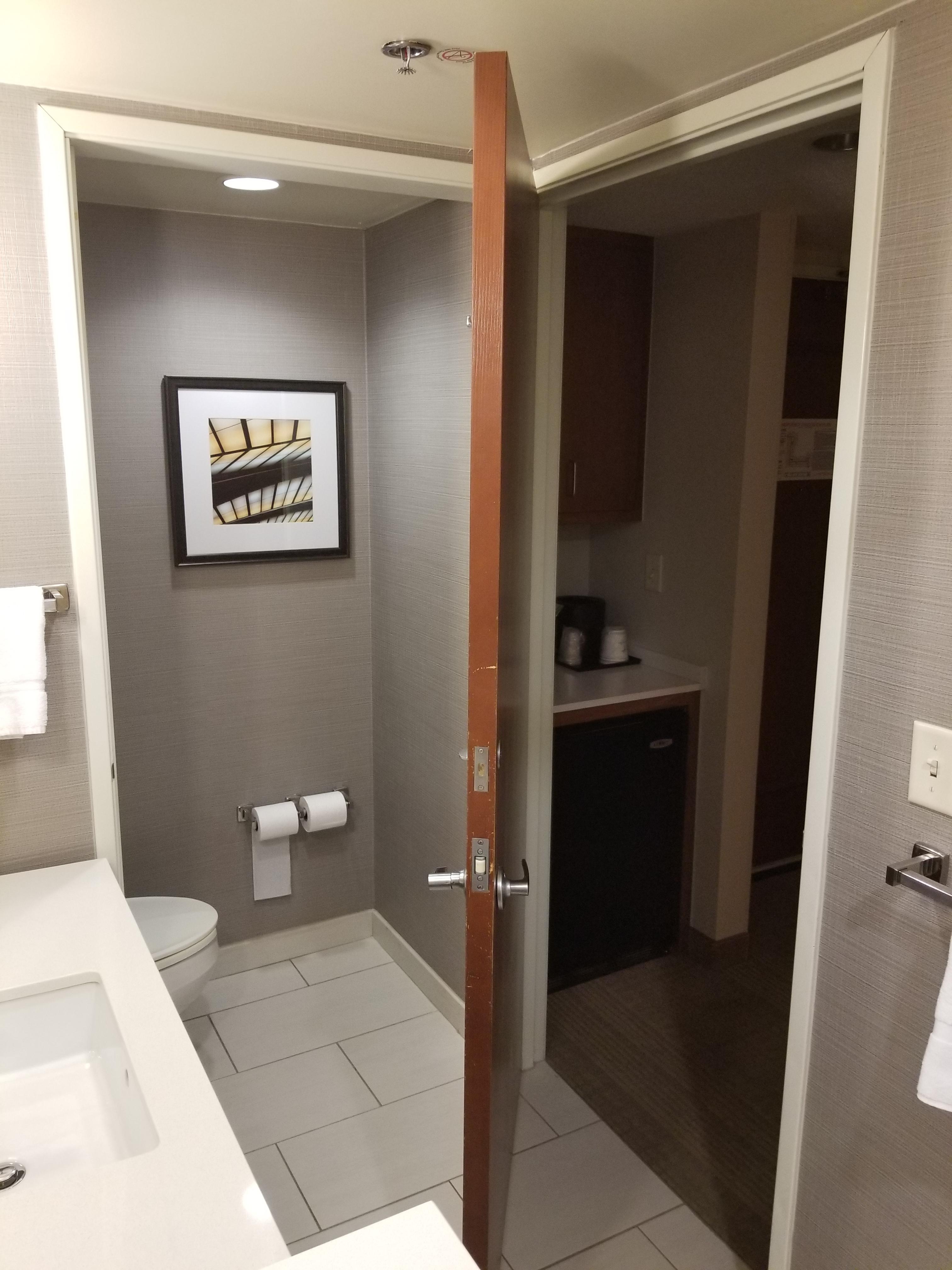 Door in hotel bathroom can close off either of 2 doorways.