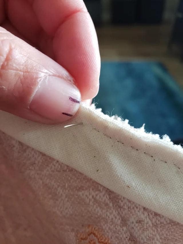 To make sure you’re sewing in a straight line, mark the nail on your thumb with two small lines.