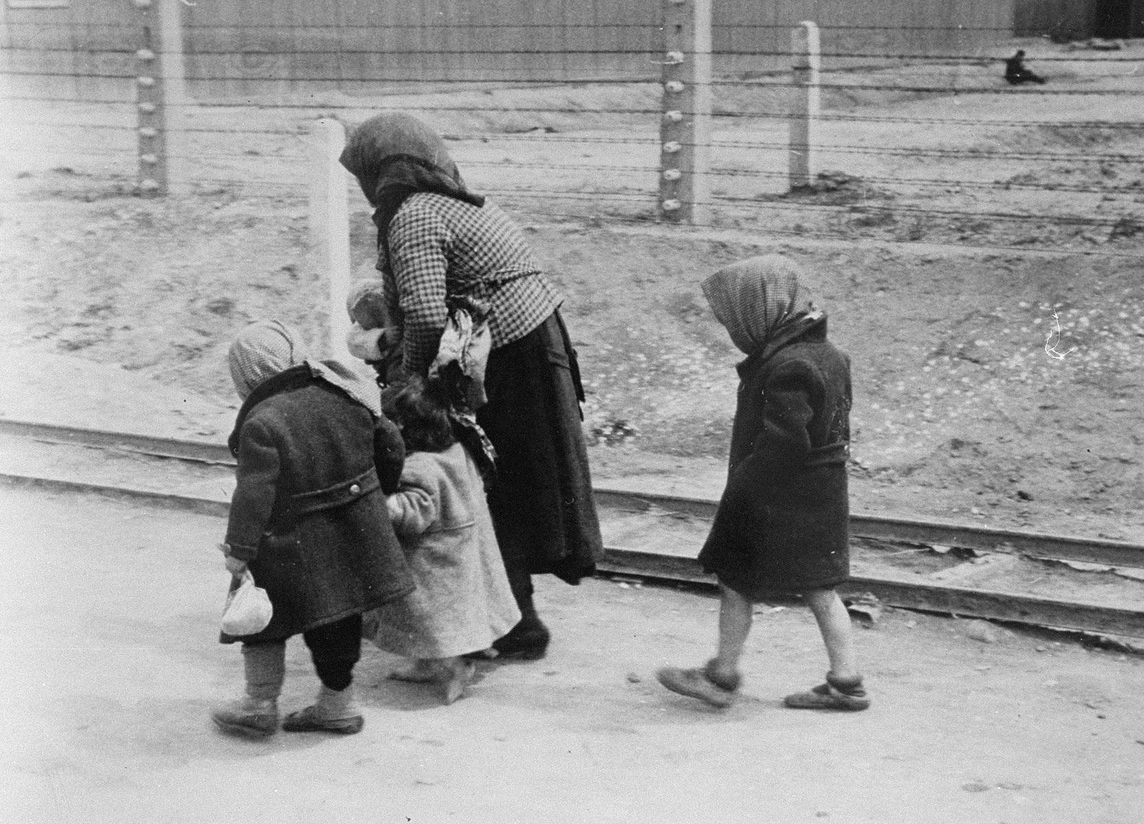 Jewish woman walking three children towards gas chamber