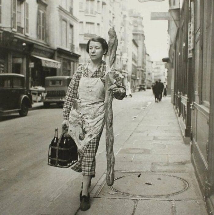 historical pictures - french woman with her baguette and six bottles of wine paris france 1945