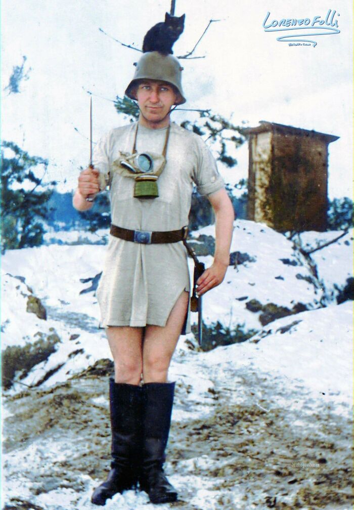 colorized photos from history - A Funny Photograph Of The First World War, German Soldier In The Snow With Only A Helmet, Boots And A Tank Top With A Cat On His Head. 1916.