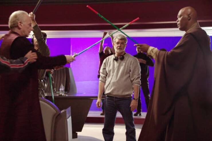 behind the scenes movies - Director George Lucas looks on while Ian McDiarmid and Samuel L. Jackson practice their laser sword duels on the set of Star Wars: Episode III — Revenge of the Sith (2005).