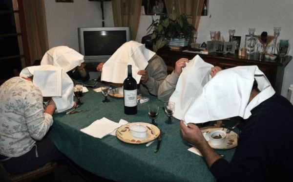 People eating the traditional French meal of ortolan bunting. The white cloth over their head is to hide their sin of eating the this particular meal from god.