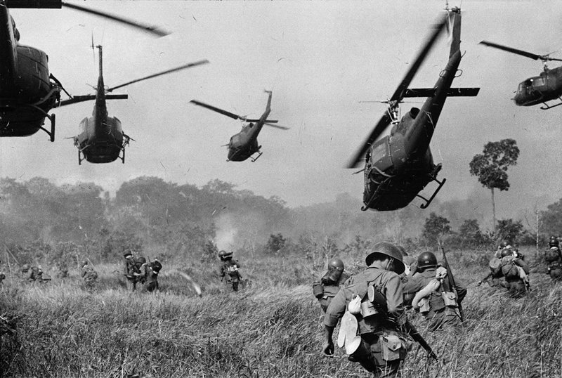 U.S. helicopters pour machine-gun fire into the tree line to cover the advance of South Vietnamese troops ca. 1965