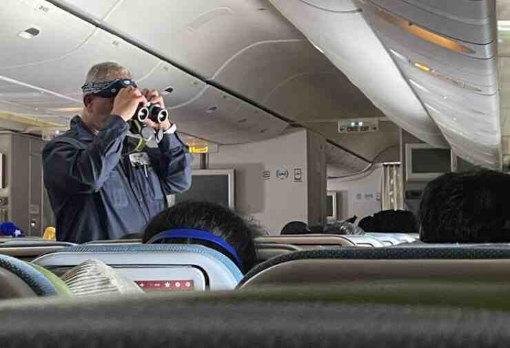 “This guy on my flight is looking out the window with binoculars from the aisle.”