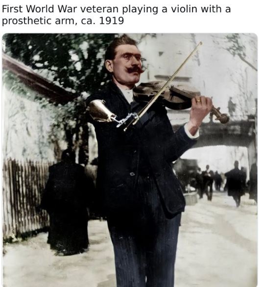 colorized historical photos - violinist - First World War veteran playing a violin with a prosthetic arm, ca. 1919