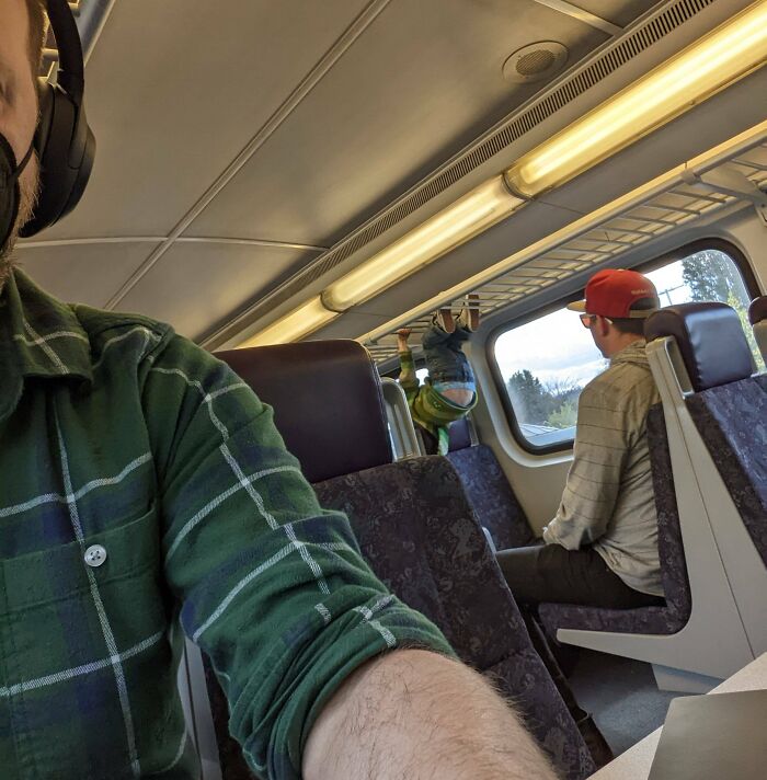 Dad Letting His Kid Climb The Luggage Rack On A Train