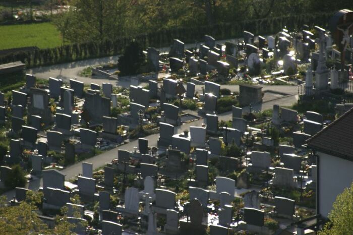 A graveyard is connected to a church while a cemetery is not.