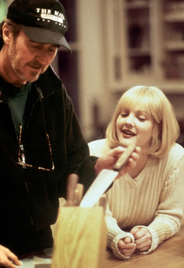 While director Wes Craven preps Drew Barrymore for the intense opening sequence in Scream (1996):