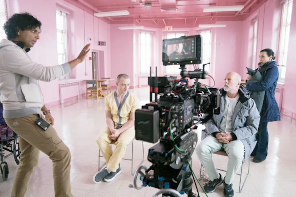 While shooting Glass (2019), M. Night Shyamalan, James McAvoy, and Bruce Willis prepare in a very pink room: